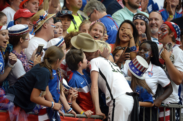 Megan Rapinoe goes in for a kiss following the match.