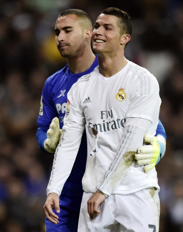 Real Madrid's Portuguese forward Cristiano Ronaldo (R) smiles next to Villarreal's goalkeeper Sergio Asenjo during the Spanish league football match Real Madrid CF vs Villarreal CF at the Santiago Bernabeu stadium in Madrid on April 20, 2016. / AFP PHOTO / JAVIER SORIANO