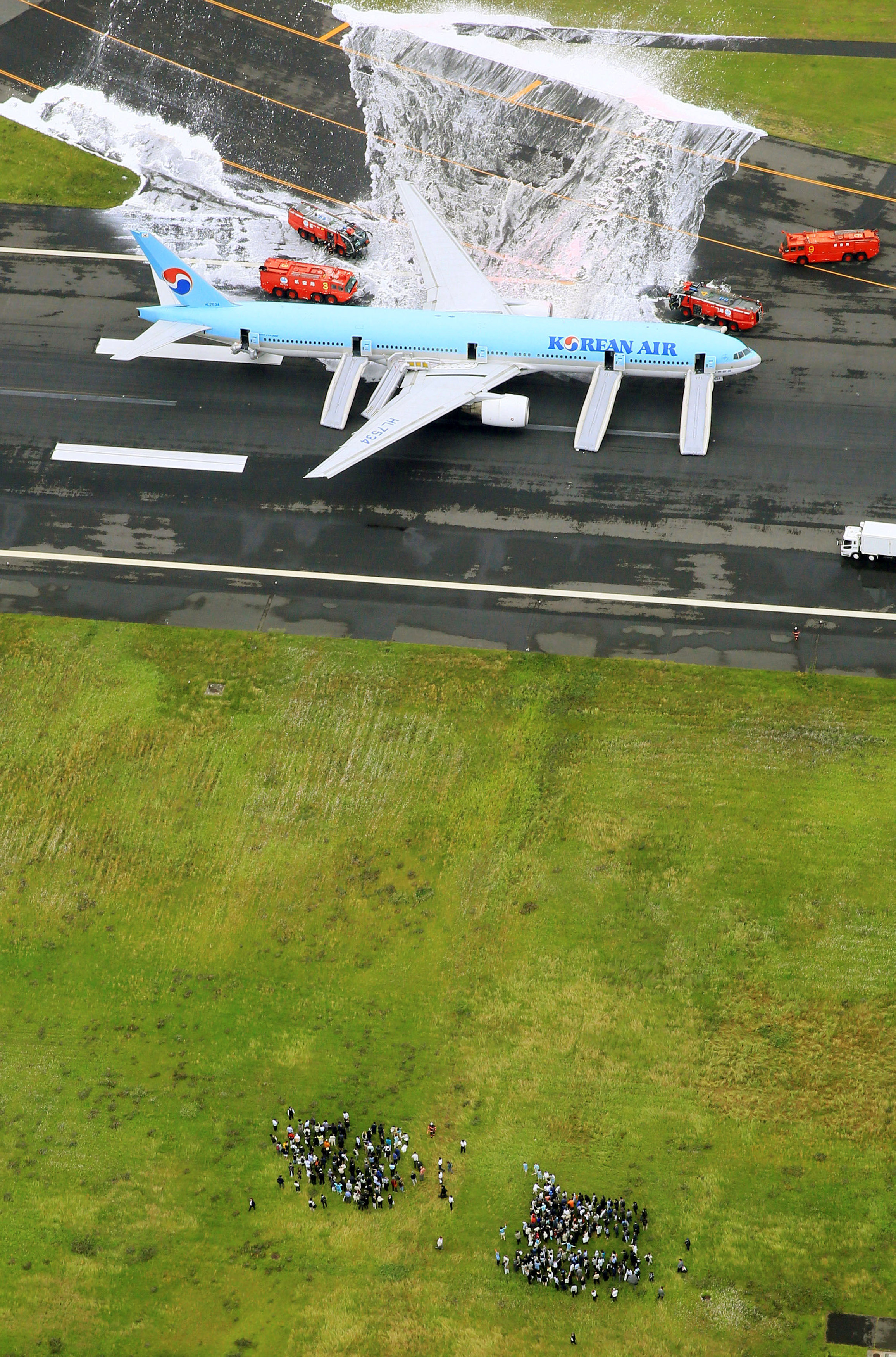 An aerial picture shows passengers standing near a Korean Air Lines plane after smoke rose from one of its engines at Haneda airport in Tokyo, Japan, May 27, 2016. Mandatory credit. Kyodo/via REUTERSATTENTION EDITORS - FOR EDITORIAL USE ONLY. NOT FOR SALE FOR MARKETING OR ADVERTISING CAMPAIGNS. THIS IMAGE HAS BEEN SUPPLIED BY A THIRD PARTY. MANDATORY CREDIT. JAPAN OUT. NO COMMERCIAL OR EDITORIAL SALES IN JAPAN.