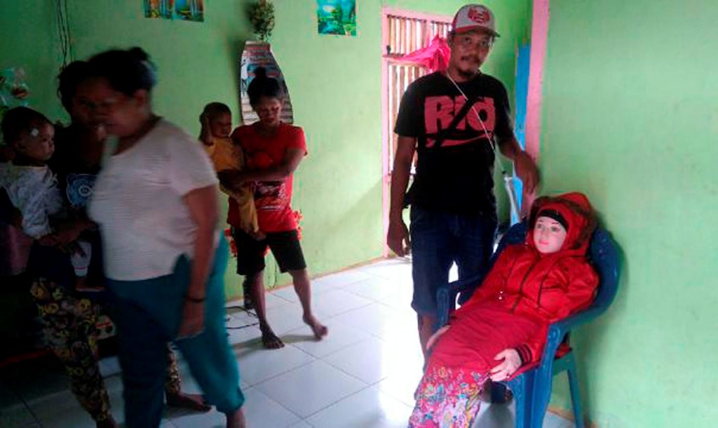 This recent undated handout picture released by Indonesian police and made available on May 3, 2016 shows an Indonesian man standing next to a sex doll (R-on chair) at a home in Banggai in Sulawesi. Indonesian villagers thought they had been blessed when a beautiful doll turned up on a beach, believing it to be an angel fallen from heaven, only to discover it was an inflatable sex toy. / AFP PHOTO / INDONESIAN POLICE / STR / -----EDITORS NOTE --- RESTRICTED TO EDITORIAL USE - MANDATORY CREDIT "AFP PHOTO / INDONESIAN POLICE" - NO MARKETING - NO ADVERTISING CAMPAIGNS - DISTRIBUTED AS A SERVICE TO CLIENTS - NO ARCHIVESSTR/AFP/Getty Images