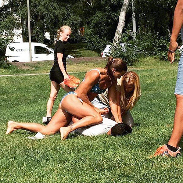 In this photo provided by Jenny Kitsune Adolffson Swedish police officer Mikaela Kellner is pinning a man to the ground who is suspected to have stolen a friend's mobile phone as she said, in Stockholm Sweden, Wednesday, July 27, 2016. She was off duty and wearing a bikini but that didn't stop her from apprehending the man. (Jenny Kitsune Adolfsson via AP)