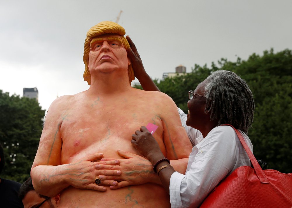 REFILE - REMOVING RESTRICTIONS A woman touches a naked statue of U.S. Republican presidential nominee Donald Trump that was left in Union Square Park in New York City, U.S. August 18, 2016. REUTERS/Brendan McDermid TPX IMAGES OF THE DAY