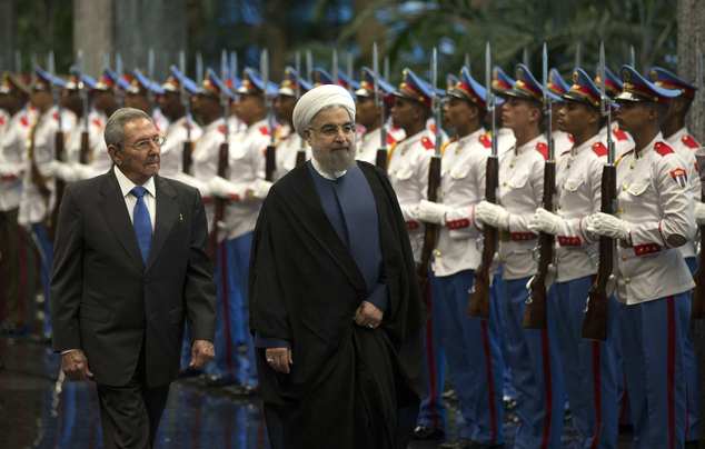 Cuba's President Raul Castro, left, escorts Iranian President Hassan Rouhani, center, as they inspect the honor guard at Revolution Palace in Havana, Cuba, Monday, Sept 19, 2016. Rouhani is on a one-day official visit to Cuba. (Ismael Francisco, Cubadebate via AP)