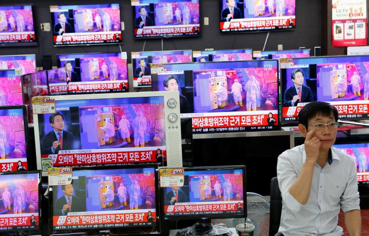 A sales assistant sits next to TV sets broadcasting a news report on North Korea's fifth nuclear test, in Seoul, South Korea, September 9, 2016. REUTERS/Kim Hong-Ji
