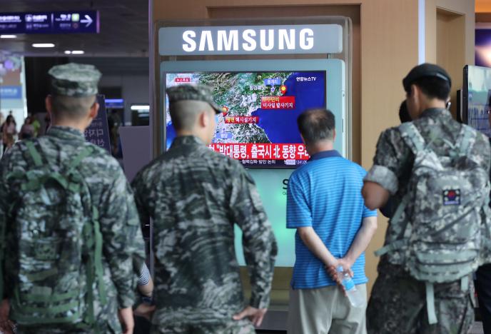 South Korean soldiers and passenger watch a TV broadcasting a news report on Seismic activity produced by a suspected North Korean nuclear test, at a railway station in Seoul, South Korea, September 9, 2016. Kim Ju-sung/Yonhap via REUTERS