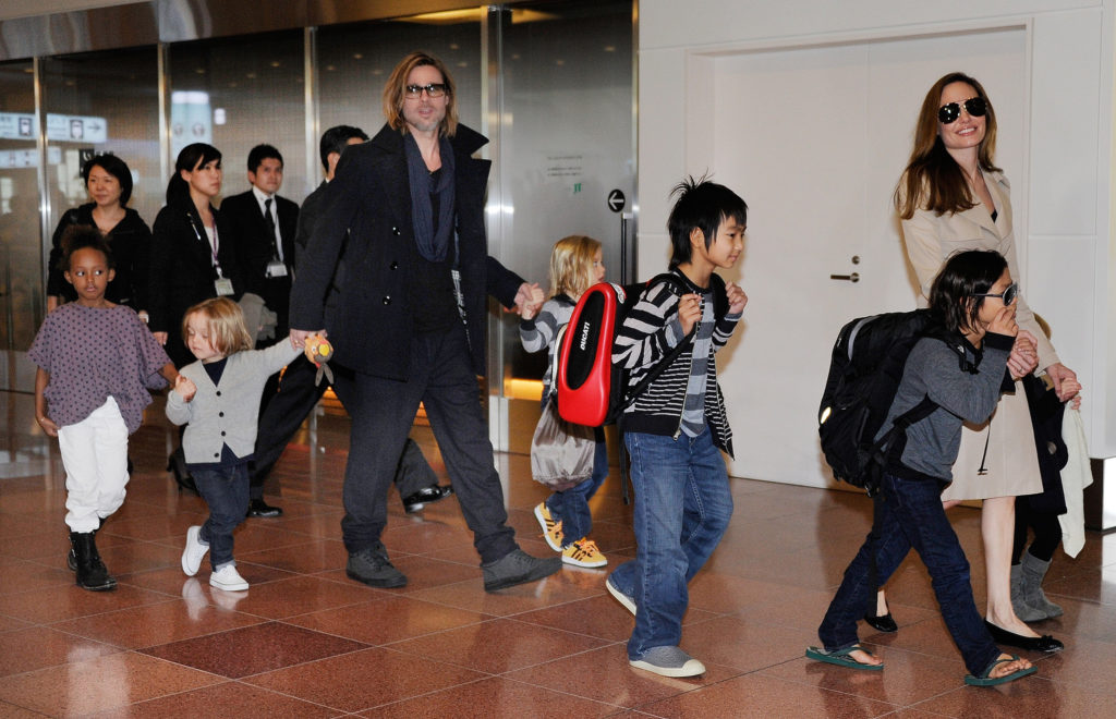 Accompanied by their six children, US movie star Brad Pitt and Angellina Jolie appear before photographers upon their arrival at Haneda Airport in Tokyo on November 8, 2011. Brad Pitt is here for the Japan premiere of his last film 'Moneyball'. AFP PHOTO/Toru YAMANAKA / AFP PHOTO / TORU YAMANAKA