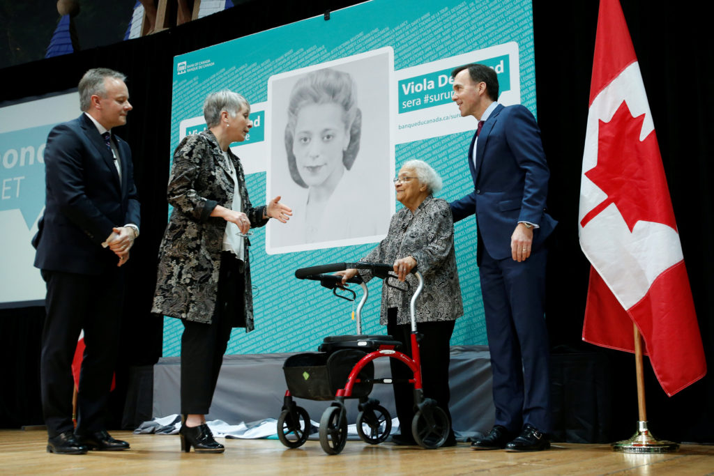 Canada's Finance Minister Bill Morneau stands with Wanda Robson after her sister Viola Desmond was chosen to be featured on a new $10 bank note during a ceremony at the Museum of History in Gatineau