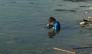 بالصور: طفلان يسبحان في مياه ملوثة بالنفايات… تحت رعاية الاهل!