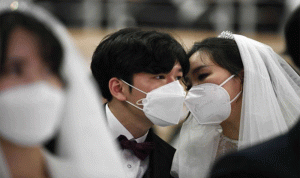 قبلات “من وراء الكمامات” في حفل زفاف جماعي