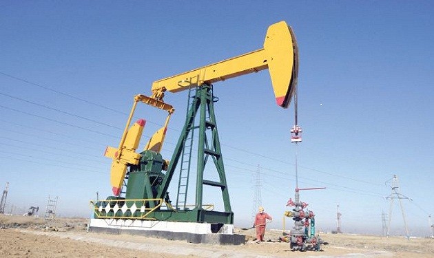 A oil field worker works at a pump jack in PetroChina's Daqing oil field in China's northeastern Heilongjiang province